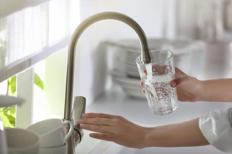 Person pouring a glass of tap water
