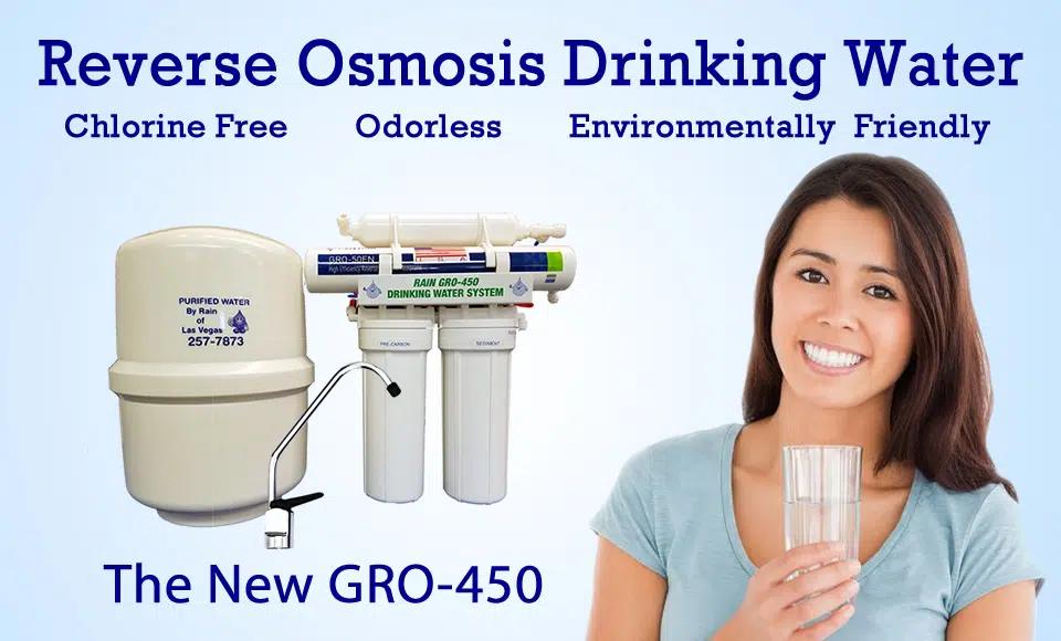 A woman smiling holding a glass of water with a GRO - 450 Water Treatment System
